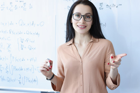 168470397-portrait-of-woman-teacher-with-glasses-near-school-board
